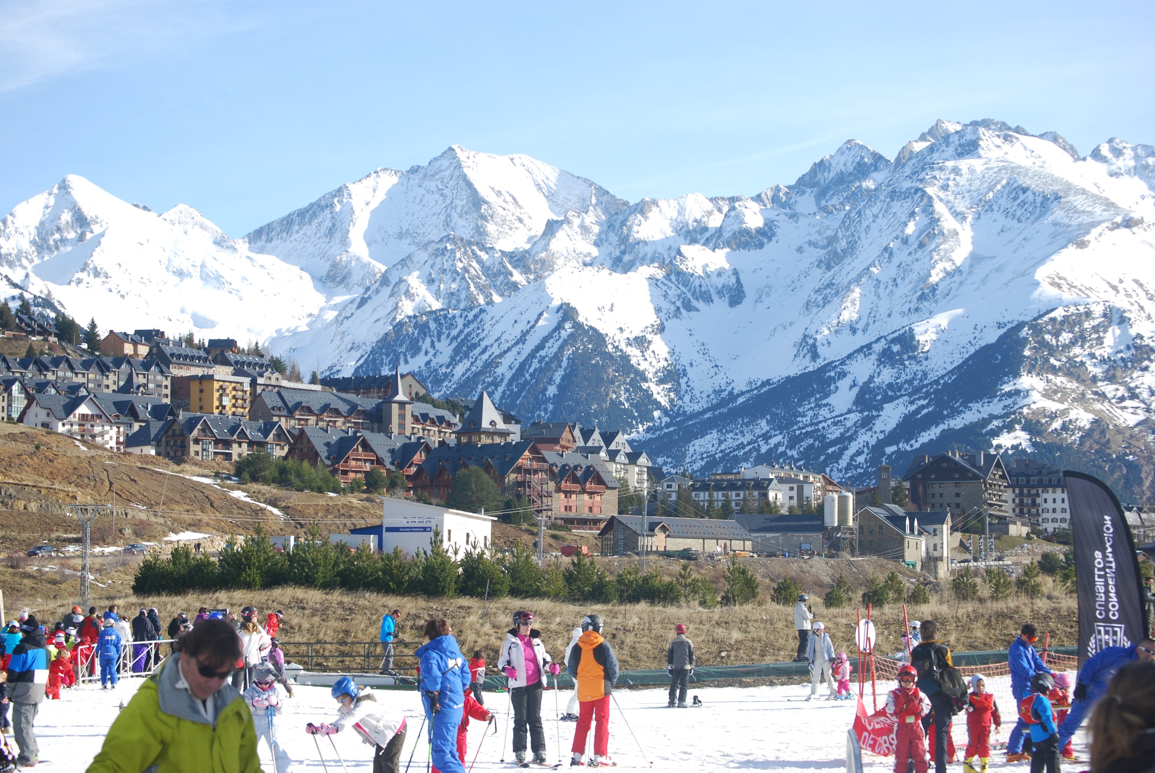 Skiing Formigal: the village below the snowy peaks of the Valle de Tena, with a ski school on the nursery slope