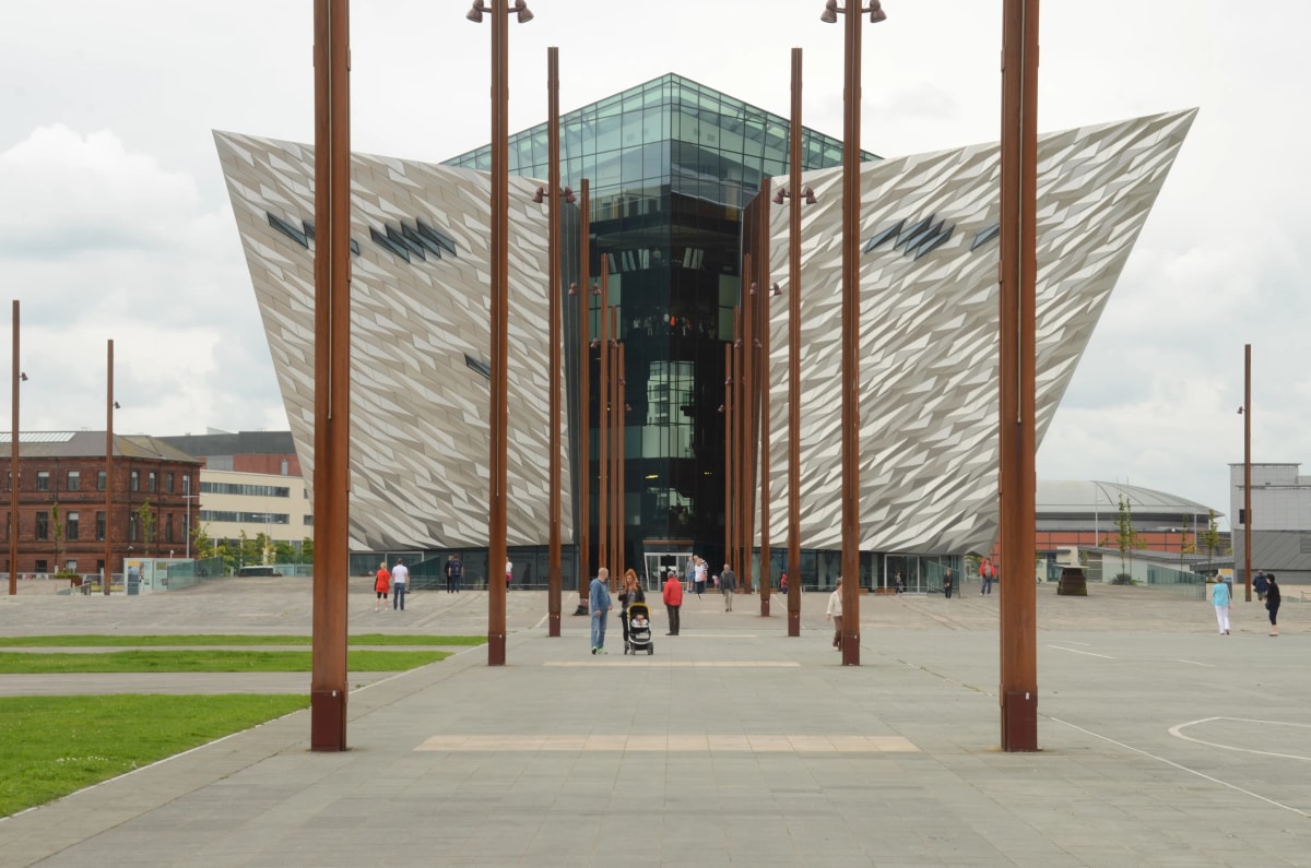 Titanic Belfast's angular silver facade rising above the open plaza on Belfast Docks, start of Chase the Sun Ireland