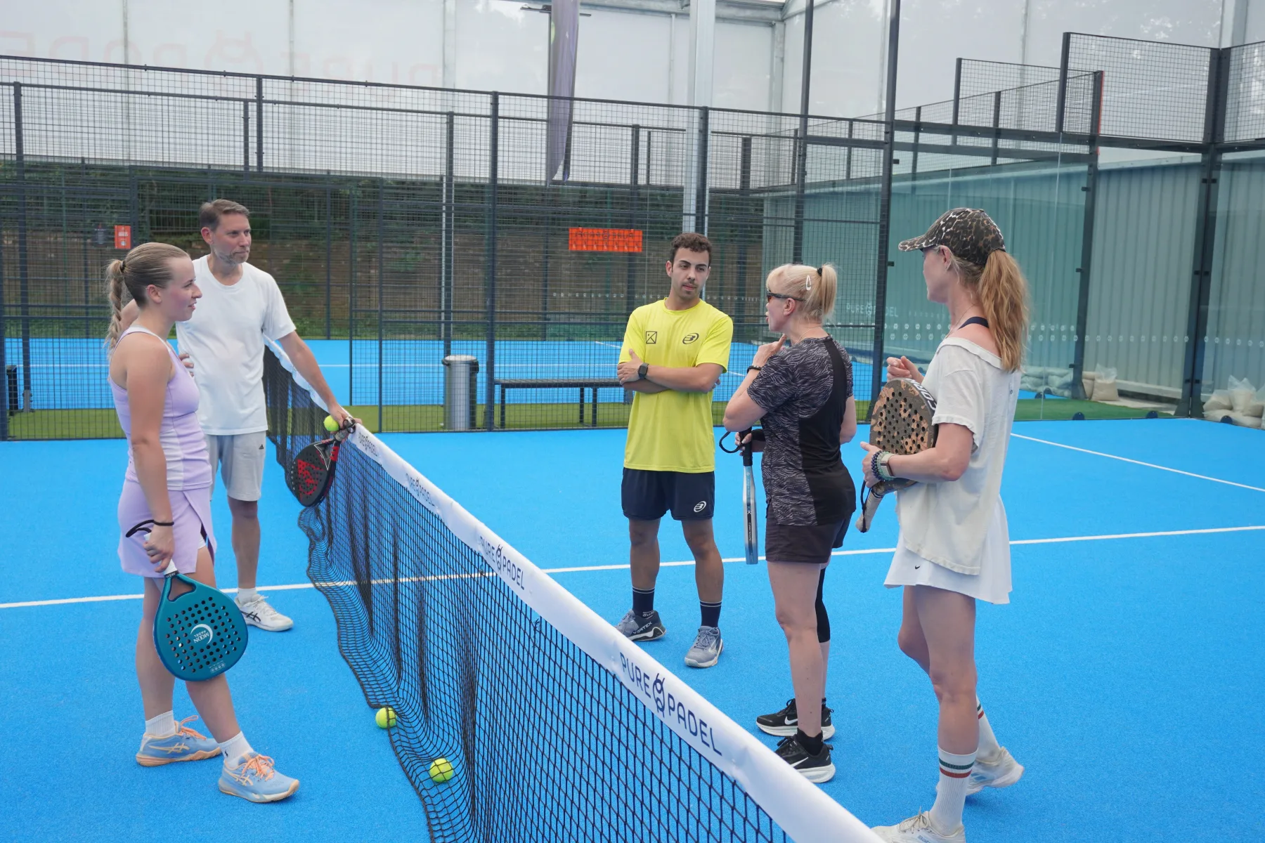 A theKlub host briefing a group on court before a session